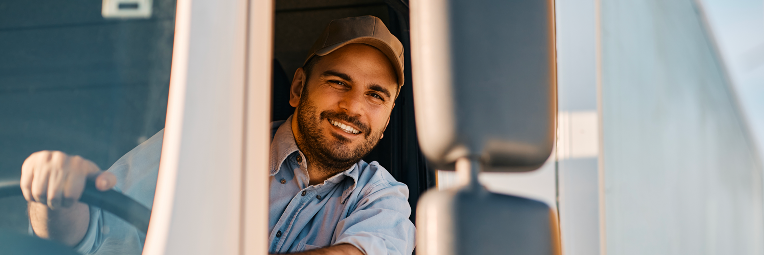 happy-truck-driver-looking-through-side-window-whi-2023-11-27-05-13-13-utc